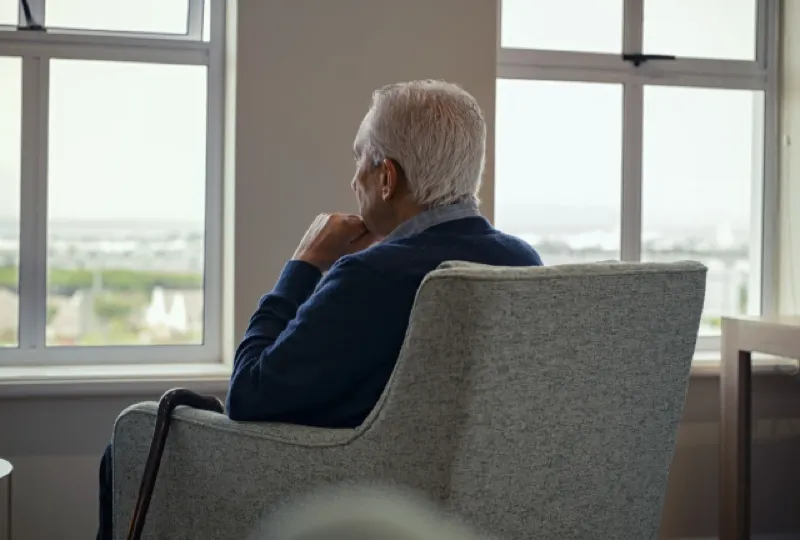 An older man looking out of a window