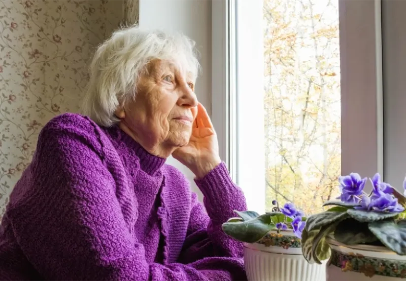 An older woman looking out of a window